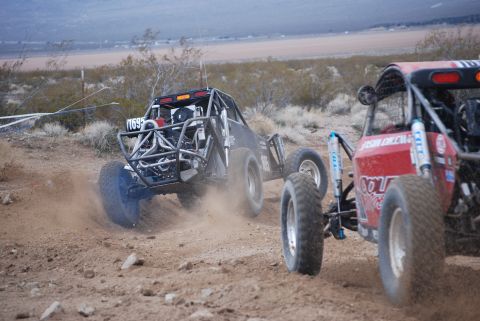 1982 Ford Bronco - Off-road buggies compete on a dusty desert track, kicking up dirt as they race.