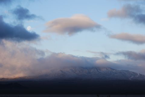 1982 Ford Bronco - The moon is visible through clouds above a snow-dusted mountain range at dusk.