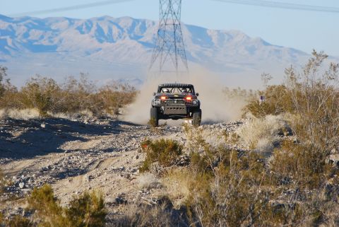 1982 Ford Bronco - Modified 1982 Ford Bronco racing on a dusty desert trail under a power line tower.