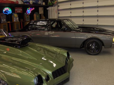 1979 Chevrolet Camaro - Two muscle cars, a green Camaro and a gray sedan, parked side-by-side in a garage.