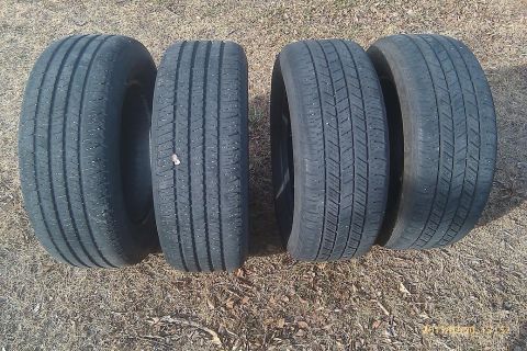 2000 Mercury Grand Marquis - Four tires are laid out on the ground, showing their tread patterns.