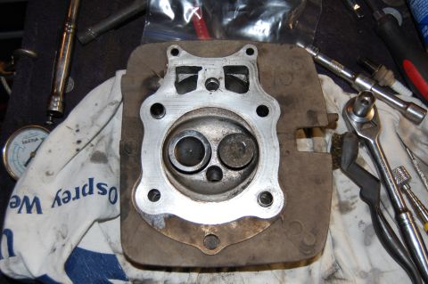 2006 Honda RANCHER - Close-up view of an engine cylinder head, showing the valves and surrounding components, with various tools laid out.