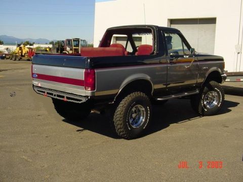 1989 Ford Bronco - This lifted Ford Bronco has a two-tone paint job and a roll cage visible through the windows.