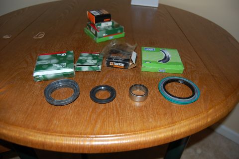 1994 Ford Bronco - Various vehicle bearings and seals are displayed on a wooden table, with product packaging in the background.