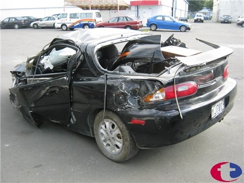 1993 Mazda MX-3 - This 1993 Mazda MX-3 sustained severe damage, impacting its roof, doors, and body.