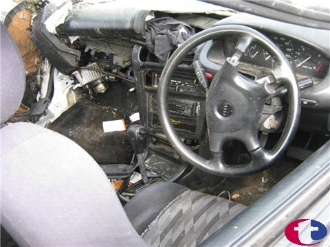 1993 Mazda MX-3 - Interior view of a severely damaged 1993 Mazda MX-3, with the dashboard and steering wheel visible.