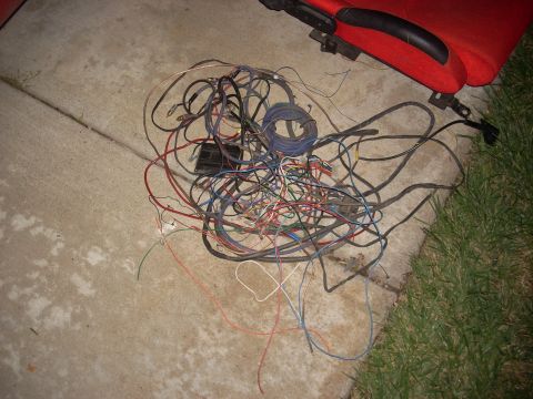 1992 Ford Ranger - A pile of tangled wires, possibly from a vehicle's wiring harness, lies on the ground.