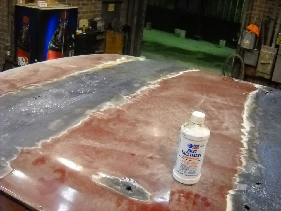 Bottle of NAPA rust treatment on a car roof being prepped for repair