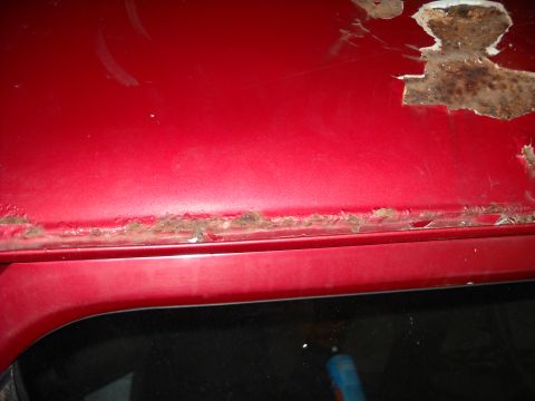 1993 Ford C-150 (Centurion Conversions) - Rust damage is visible along the seam of a red vehicle's roofline.