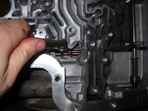 1993 Ford C-150 (Centurion Conversions) - A hand is shown adjusting a part within a complex metal transmission valve body.