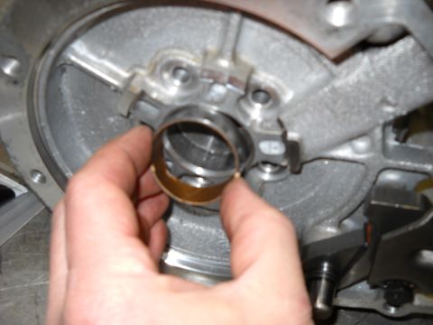 1993 Ford C-150 (Centurion Conversions) - Close-up of a hand holding a bearing during the rebuild of an E4OD transmission.