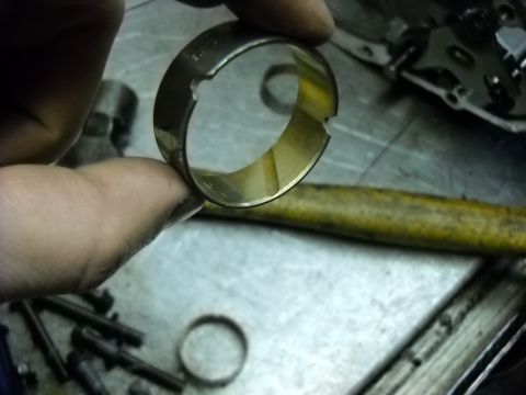 1993 Ford C-150 (Centurion Conversions) - Close-up of a worn transmission part held in a hand, with tools in the background.