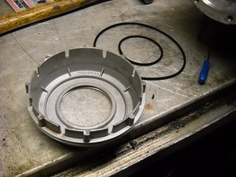 1993 Ford C-150 (Centurion Conversions) - Close-up of a metal transmission component and a rubber seal on a workbench.