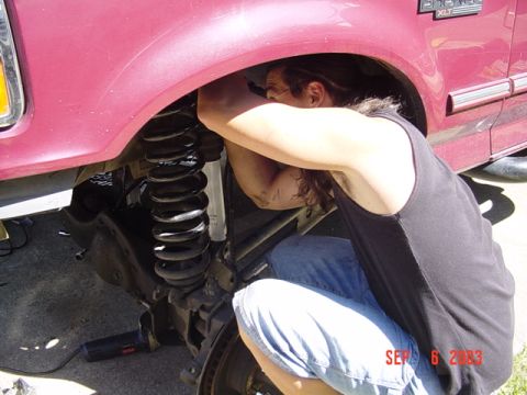 1989 Ford Bronco - A person works on the suspension of a maroon vehicle. The date stamp indicates the photo was taken on September 6, 2003.