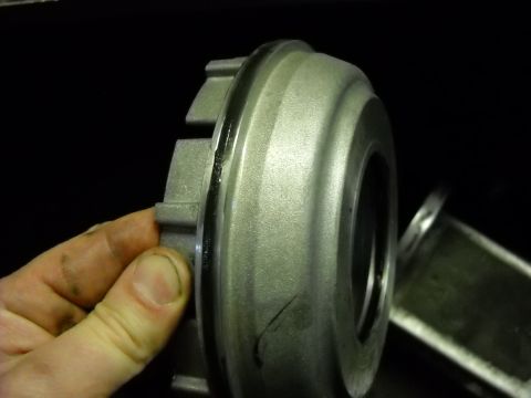 1993 Ford C-150 (Centurion Conversions) - A metal clutch component is examined, revealing its machined surfaces and ribbed exterior.