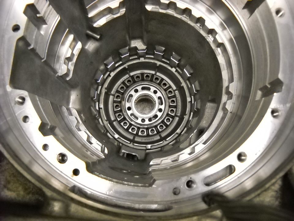 Transmission torque converter housing interior with circular array of bolts and internal gears