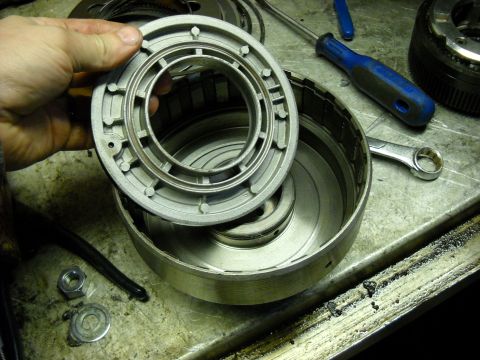 1993 Ford C-150 (Centurion Conversions) - Disassembled transmission components and tools are laid out on a workbench for repair.