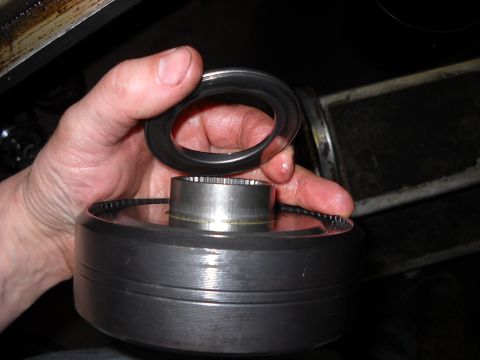 1993 Ford C-150 (Centurion Conversions) - A hand holds a metal ring above a splined cylinder, possibly a part from a vehicle's transmission.