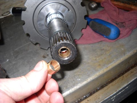 1993 Ford C-150 (Centurion Conversions) - A hand holds a bronze bushing, with a splined shaft and gear assembly in the background.
