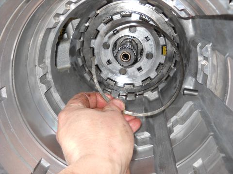 1993 Ford C-150 (Centurion Conversions) - A snap ring is held in place during a transmission rebuild, likely for an E4OD transmission.