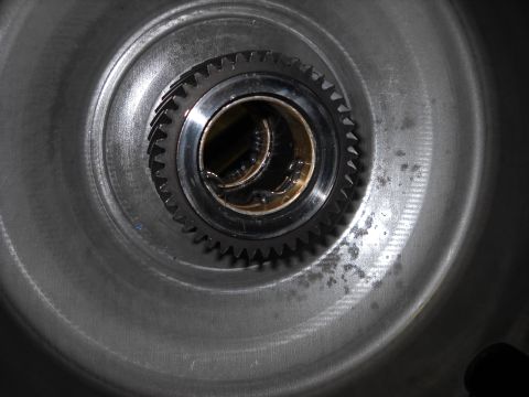 1993 Ford C-150 (Centurion Conversions) - A close-up view of a transmission gear, showing its internal splines and a bronze bushing, likely part of an E4OD rebuild.