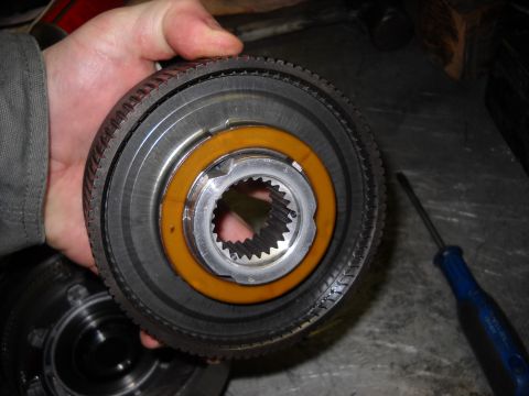 1993 Ford C-150 (Centurion Conversions) - A hand holds a disassembled transmission part, revealing internal splines and a distinct orange ring.