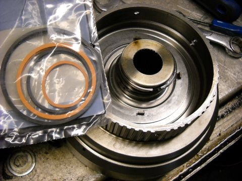 1993 Ford C-150 (Centurion Conversions) - Transmission drum and seals laid out on a workbench, ready for rebuild.
