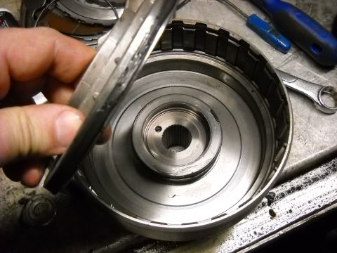 1993 Ford C-150 (Centurion Conversions) - Disassembled transmission part held by hand over the main component.