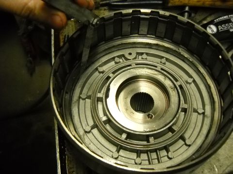 1993 Ford C-150 (Centurion Conversions) - A mechanic uses a caliper to measure a part of a disassembled automatic transmission clutch pack.