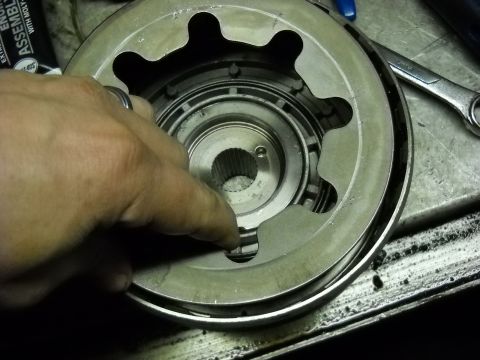 1993 Ford C-150 (Centurion Conversions) - Close-up of a transmission clutch pack component being held by a hand, with tools nearby.
