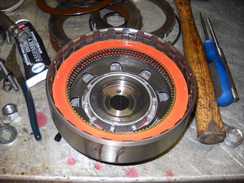 1993 Ford C-150 (Centurion Conversions) - A close-up view of a transmission clutch pack assembly, with tools and lubricant nearby.