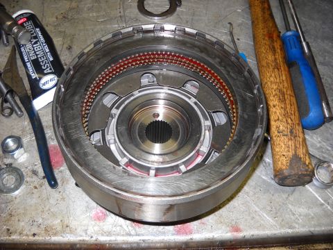 1993 Ford C-150 (Centurion Conversions) - A disassembled transmission clutch pack sits on a metal surface next to a tube of assembly lube and various tools.