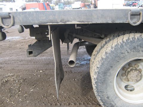 1972 Ford F-250 - A close-up view of the rear wheel and chassis of a truck, showing its mud flaps and exhaust system.