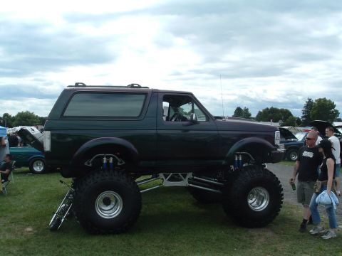 1993 Ford Bronco - A heavily modified 1993 Ford Bronco is displayed outdoors, its extreme lift and large off-road tires.