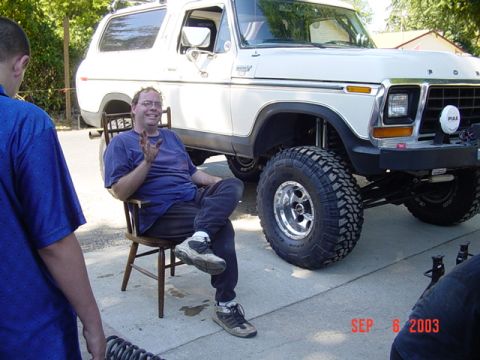 1989 Ford Bronco - A white 1978 Ford Bronco with significant suspension lift and off-road tires is parked outside.