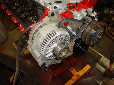 1989 Ford Bronco - Close-up of an engine's alternator and related components, with the valve cover off.