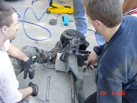 1989 Ford Bronco - Two men work on a vehicle's suspension component, with a date stamp of SEP 6 2003 visible.