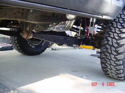 1989 Ford Bronco - Close-up of the undercarriage and suspension system of a modified SUV.