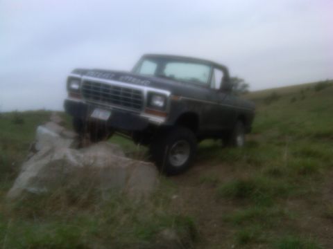 1978 Ford Bronco - This 1978 Ford Bronco navigates rocky terrain under an overcast sky.