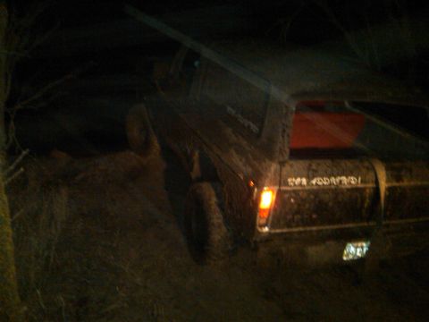 1978 Ford Bronco - Muddy 1978 Ford Bronco navigating rough terrain in the dark.