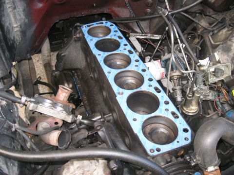 1981 Ford Bronco - Close-up view of an engine block with a new gasket being prepared for installation.
