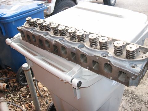 1981 Ford Bronco - A disassembled engine cylinder head with multiple valves and springs is shown in a close-up view.