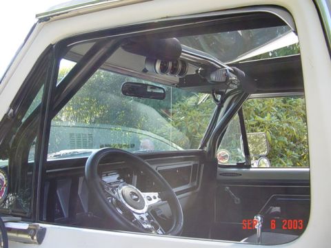 1989 Ford Bronco - Interior view of a white SUV, a roll cage, aftermarket steering wheel, and gauges mounted on the headliner. The date stamp reads SEP 6 2003.
