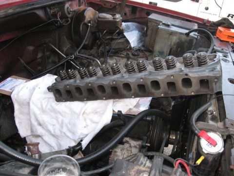 1981 Ford Bronco - Removed engine cylinder head with valves and springs visible, part of engine bay mechanics.