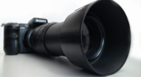 1993 Ford Taurus - A black Sony camera is shown with a lens and lens hood attached, against a white background.