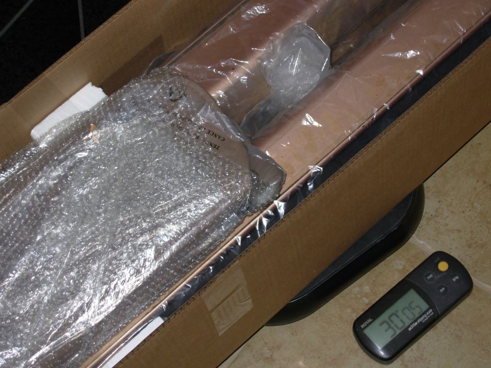 Automotive part in bubble wrap inside open box on a scale