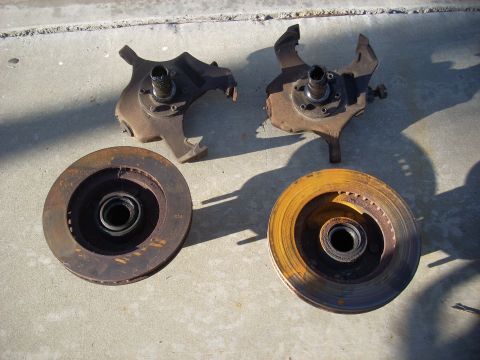 1992 Ford Ranger - Two front wheel knuckles and brake rotors are shown resting on a concrete surface.