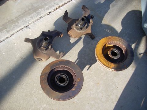 1992 Ford Ranger - Several automotive brake parts, including rotors and steering knuckles, are laid out on a concrete surface.