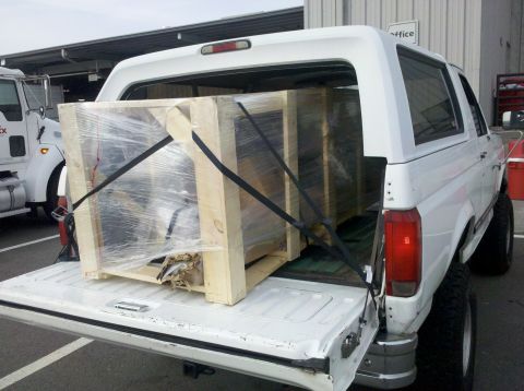 1995 Ford Bronco - White Ford Bronco loaded with cargo, parked next to a FedEx truck.
