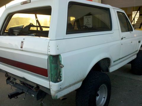 1995 Ford Bronco - This white Ford Bronco is missing its rear taillight assembly and appears to be undergoing some work.
